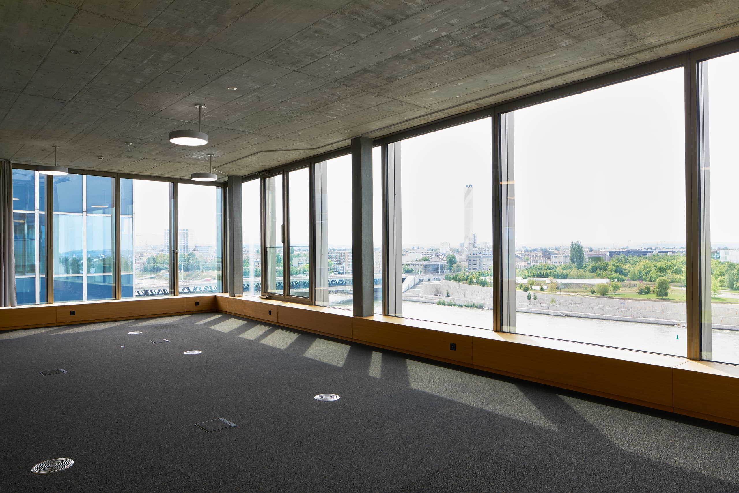 View of a large multifunctional room in the building WKL-132 in the Klybeck site in Basel with large windows and textile floors