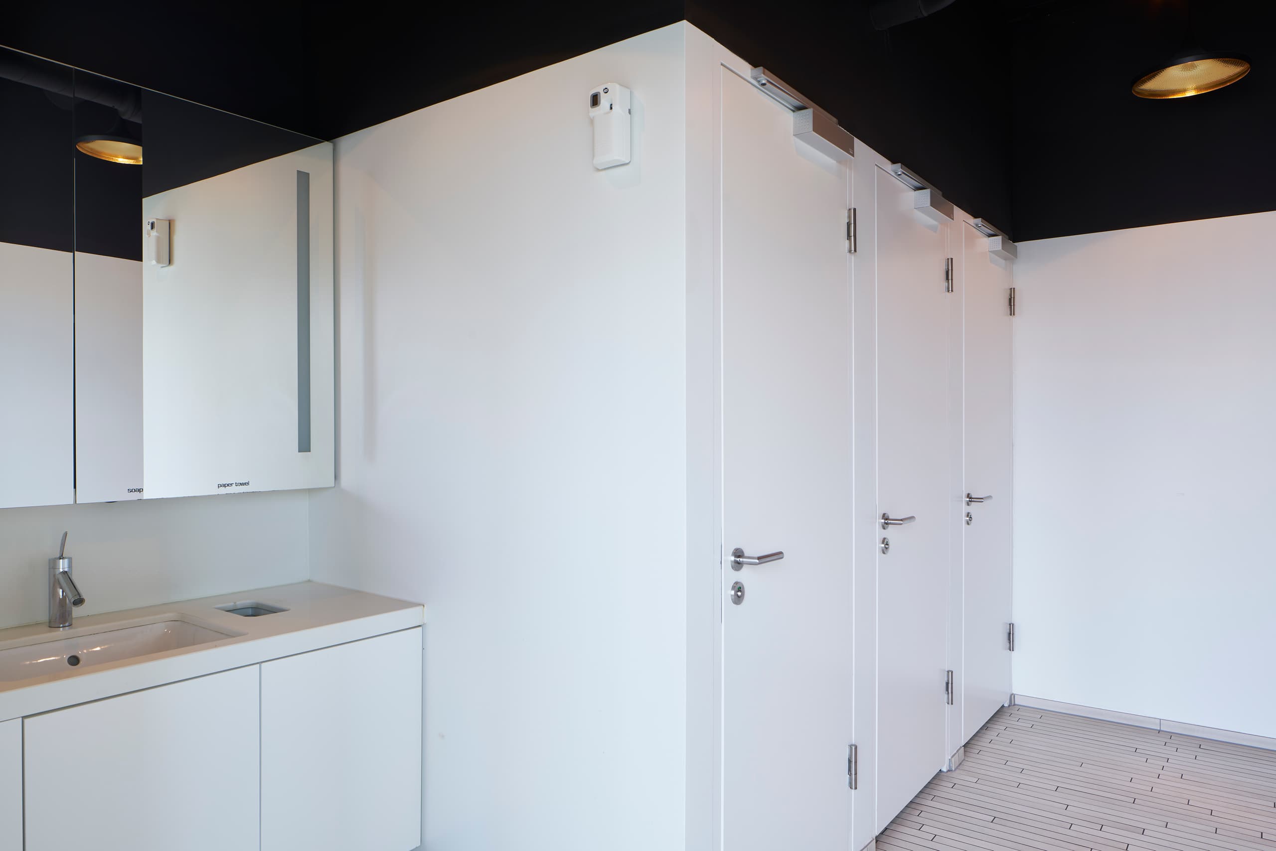 View of three white toilet cubicles inside the building WKL-132 on the Klybeck site in Basel